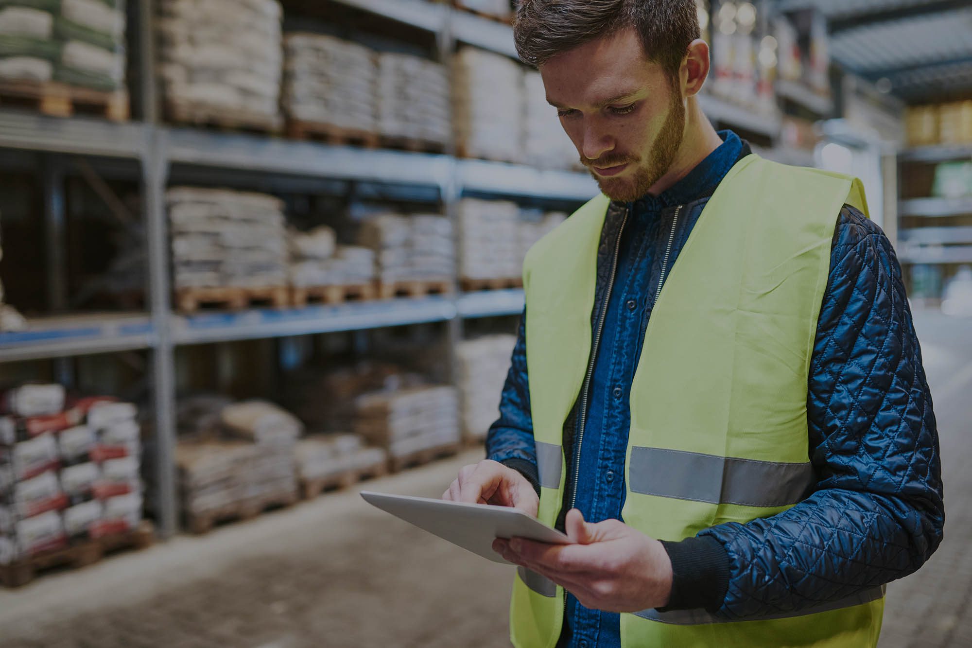 Person in a warehouse checking a tablet pc for inventory data - rfid solutions