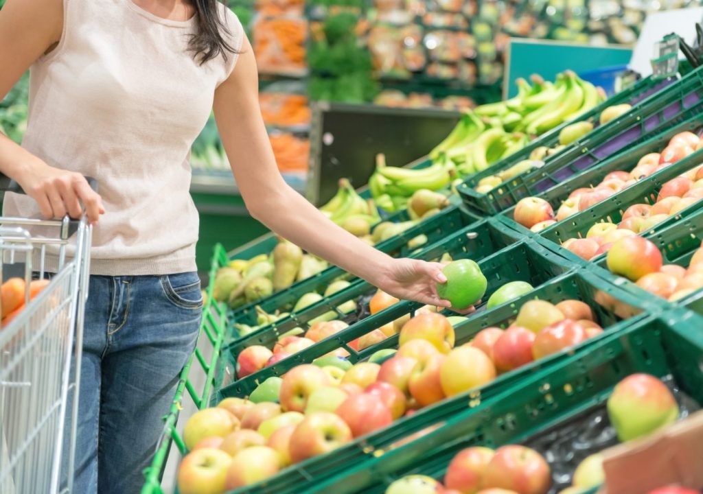 Person shopping in a fruit and vegetable section at a retailer - RFID ensures that fresh food is always avaialble thanks to delivery accuracy