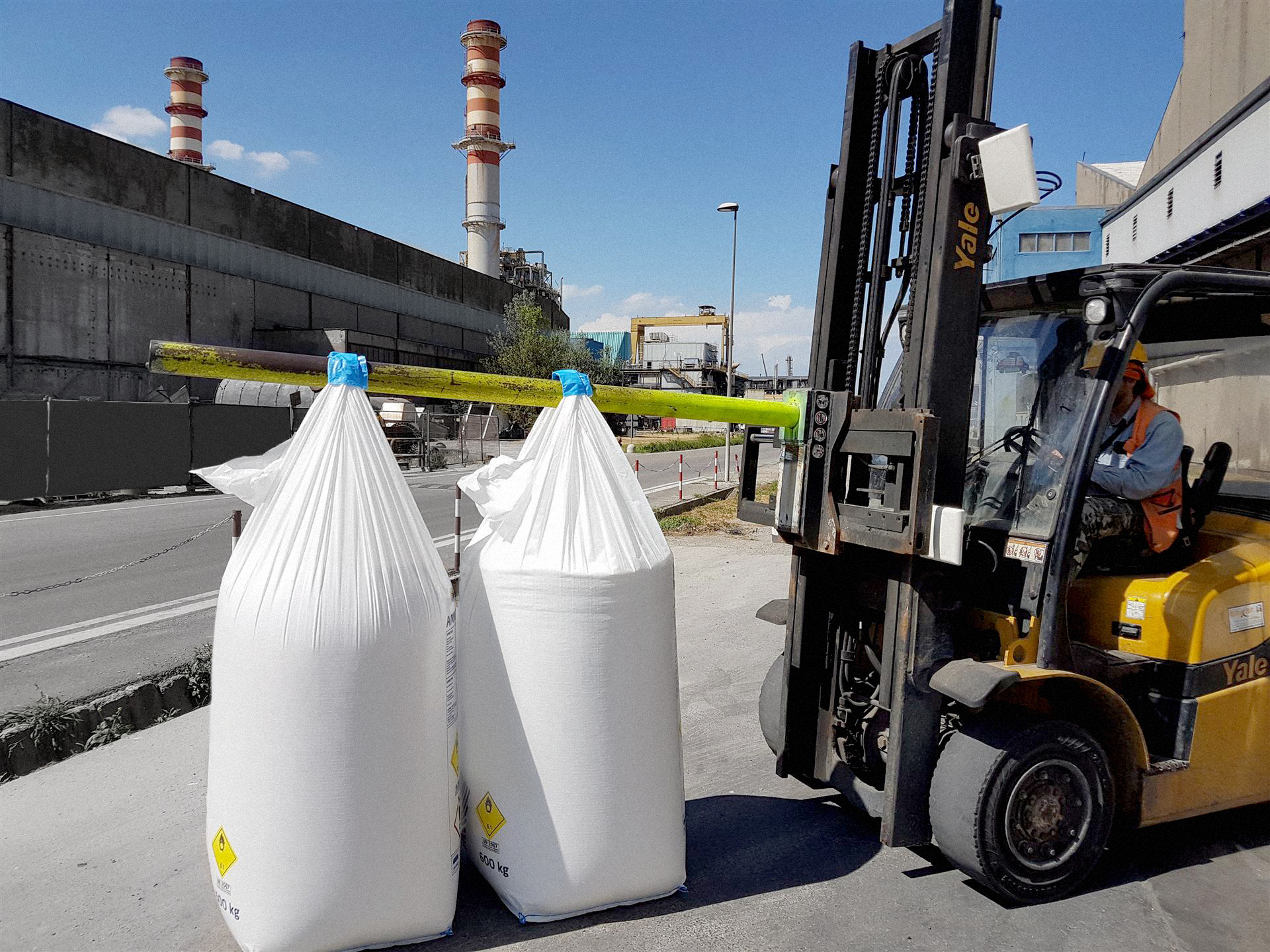 Picture of an industrial forklift or payloader carrying two big bags