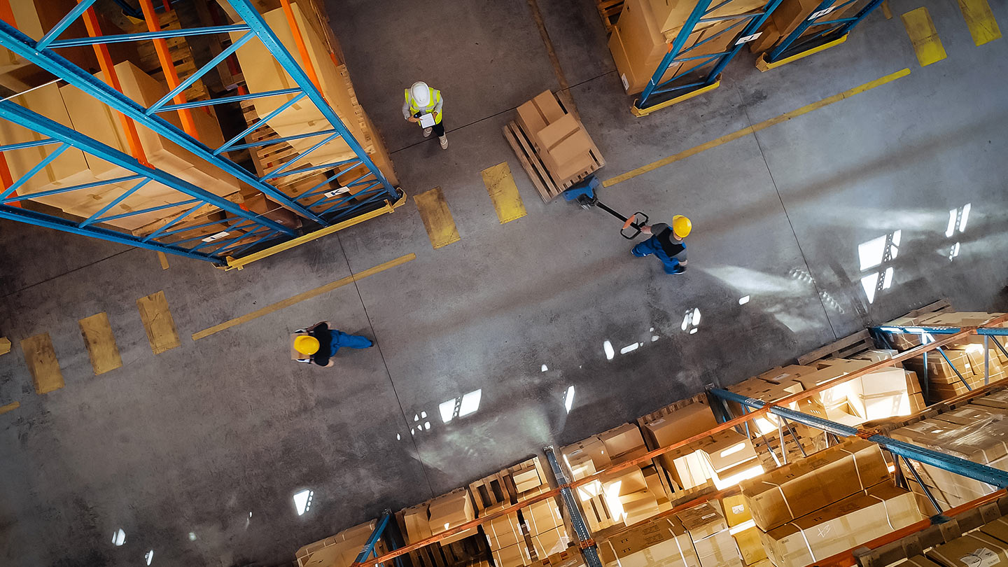 Birdseye view of a large warehouse with employees depicted from above