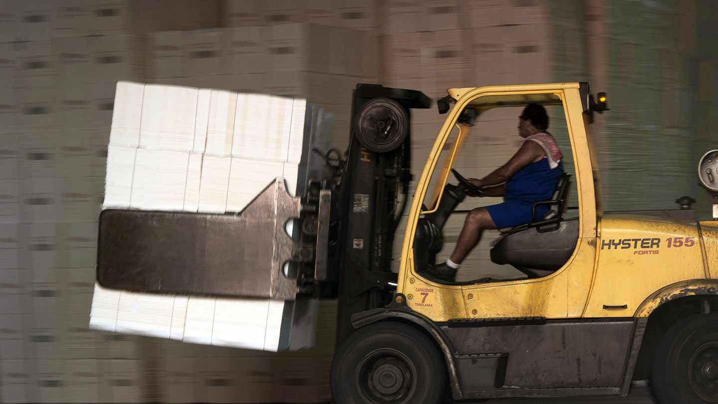 A specialized forklift carrying a pulp bale