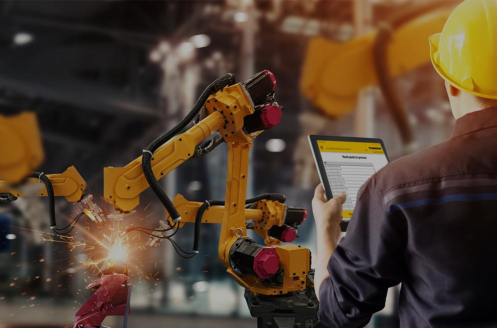 Person in front of robot arms looking at a tablet computer