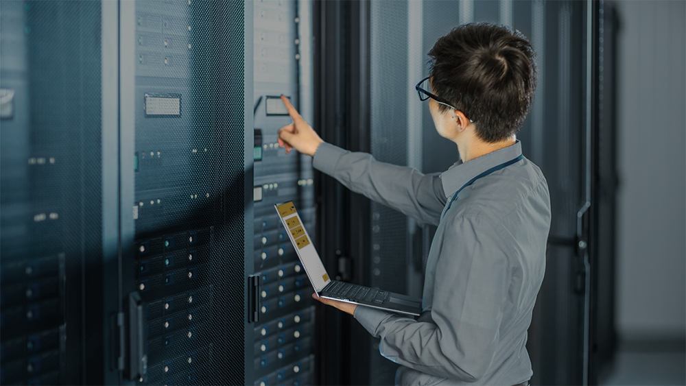 A person entering a server room holding a laptop