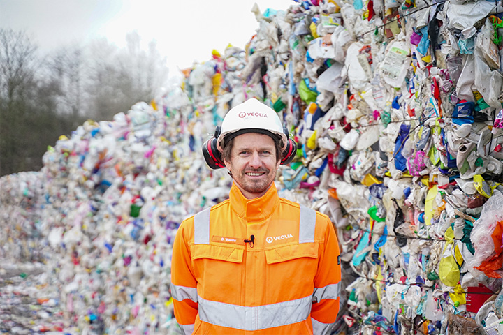 Picture of David Wardle of Circpack by Veolia standing in front of a a pile of recycled plastic waste