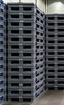 Stacked grey pallets and crates made out of plastics, side showcases the place for RFID tags or barcodes
