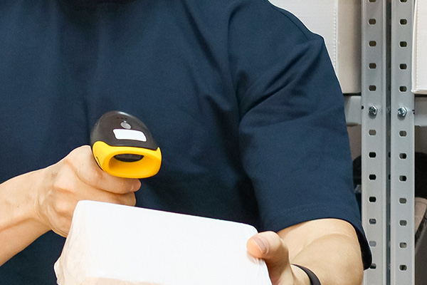 Closeup to barcode scanning, a person, scanner and box