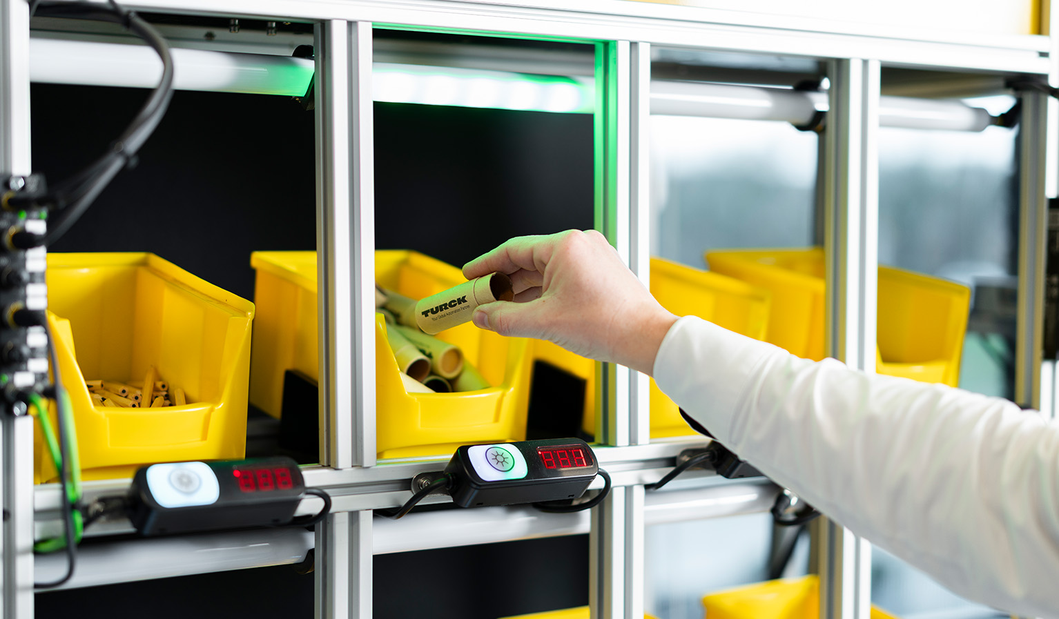 A unit with shelves equipped with buttons and lights to accomodate little plastic boxes for the storage of smallish items