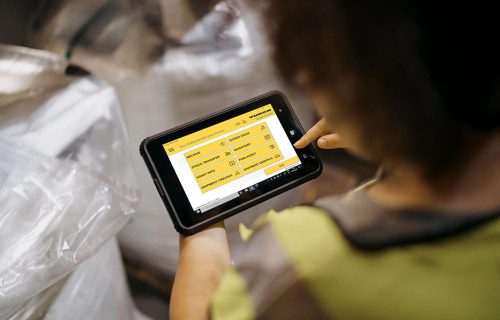 Turck Vilant Mobile Client main screen Looking over a shoulder of a person using a tablet computer in a warehouse setting